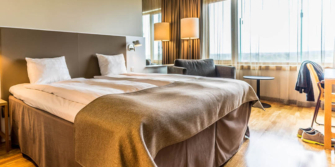 Produkter och tjänster 6 Svenska: En kvinnlig mässpersonal visar en karta för två kvinnliga besökare vid en informationsdisk. English: A female exhibition staff member shows a map to two female visitors at an information desk.