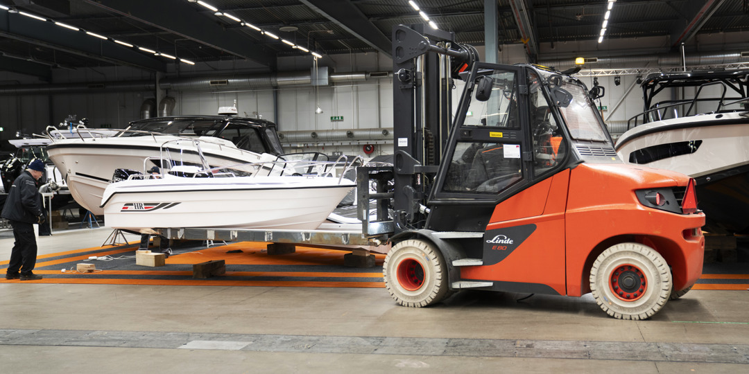 Products and services 2 Orange truck som flyttar en motorbåt under Allt för sjön