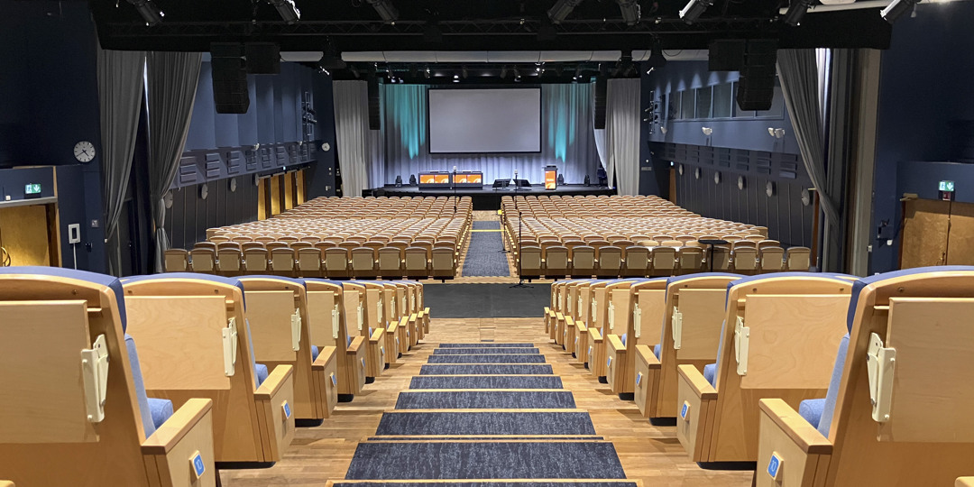 Auditorium K1+K2 with stage and large screen, ready for conferences or presentations.