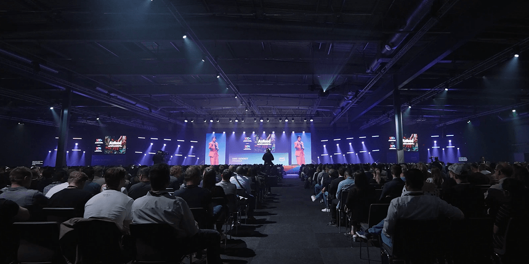 Utställningsportal med bild av tre tunnelarbetare upplysta bakifrån, stående i en tunnel under World Tunnel Congress på Stockholmsmässan.
