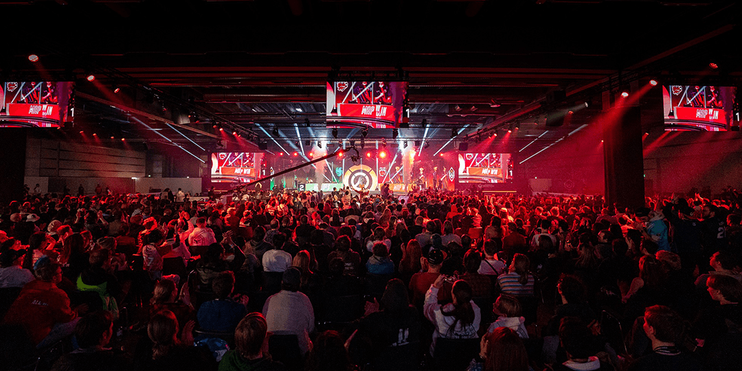 Audience watching a DreamHack final with stage lighting, screens and esports in focus.