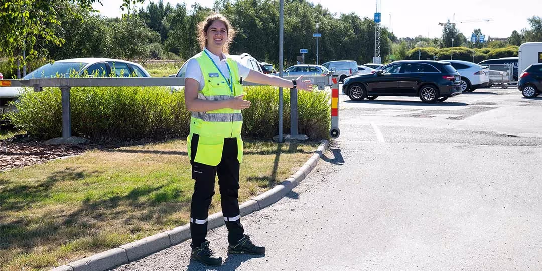 person som bär gul väst och hänvisar till parkeringen