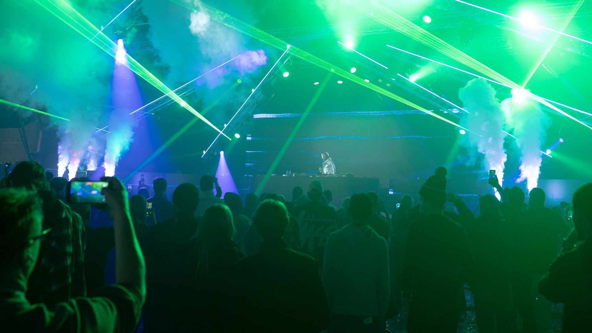 Visitors in an event hall with large screens during a competition at DreamHack in Stockholm.