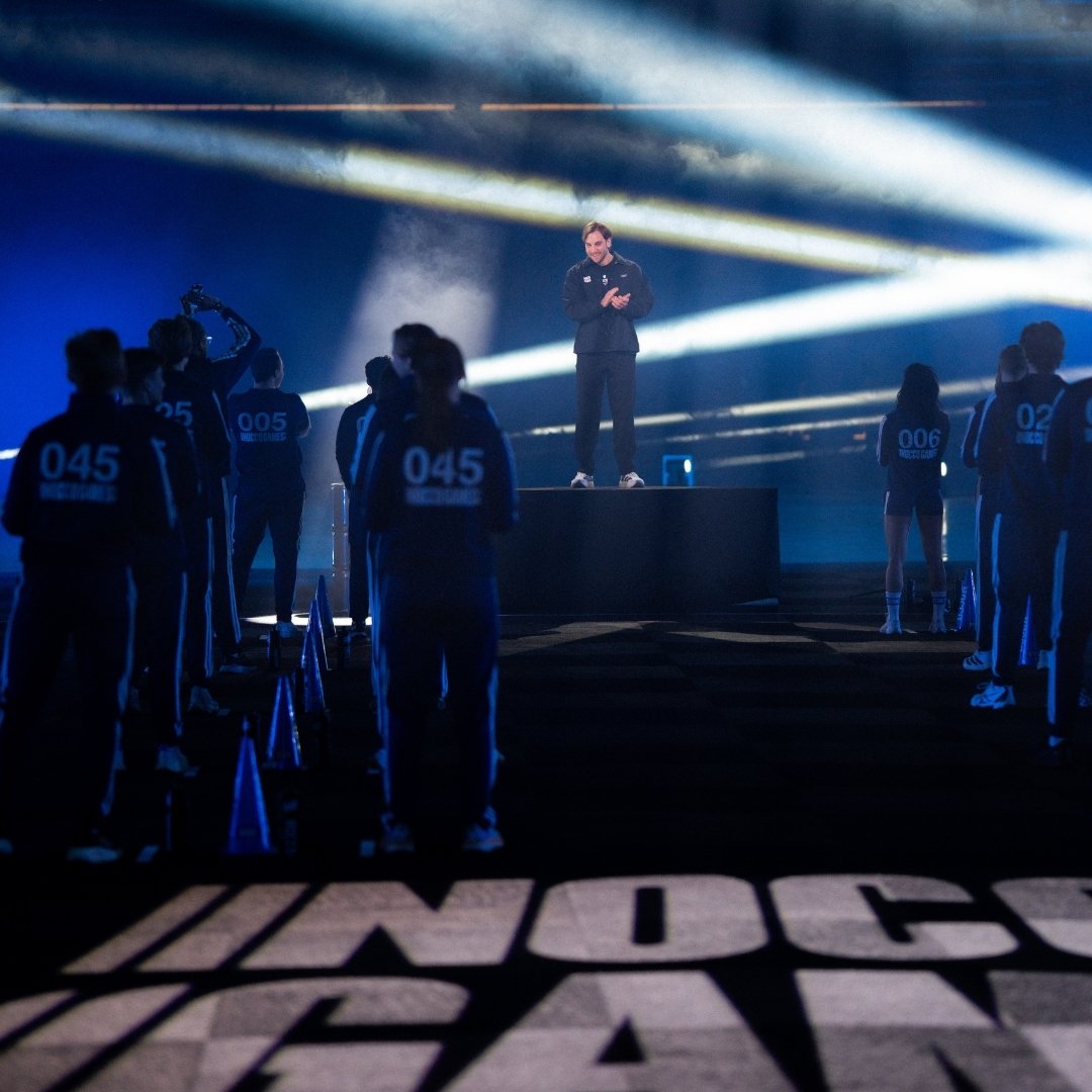 Besökare i eventhall med stora skärmar under ett esportevent.
